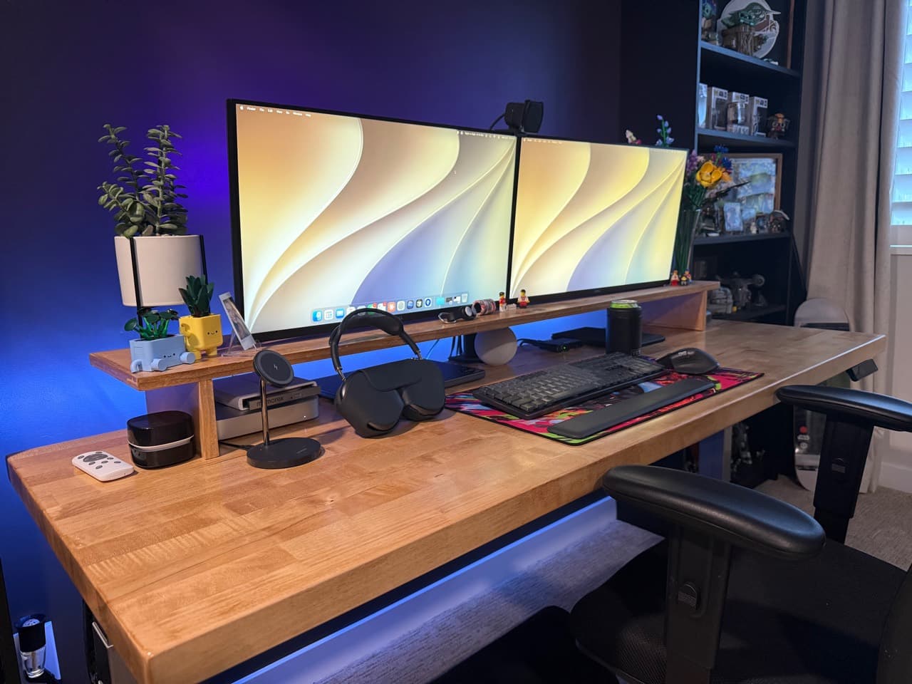 Richard's desk setup with dual ultrawide displays, a wood desk shelf, keyboard, mouse, headphones, and ambient blue lighting